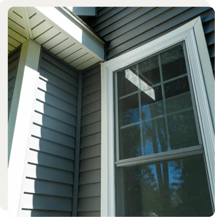 White-trim double-hung window on gray siding